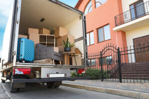 Moving truck loaded with furniture and boxes outside a house, conveying relocation, new beginnings, and lifestyle changes.